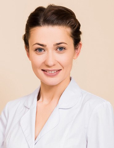 beautician standing behind massage table and smili TWRLC9H team